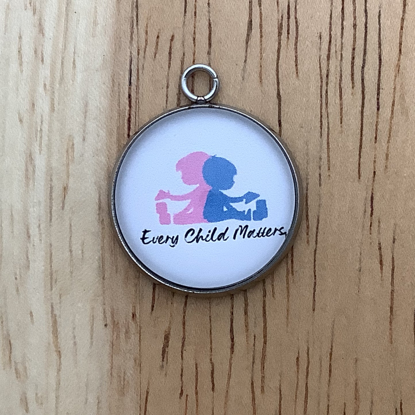a pink and blue graphic of two children playing. Wording 'every child matters'