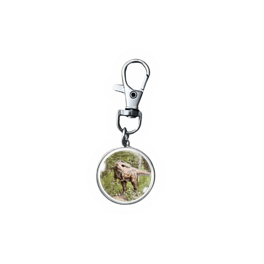 Handmade T-Rex dinosaur zipper pull charm in a forest setting with stainless steel swivel clasp and 18mm glass cabochon.