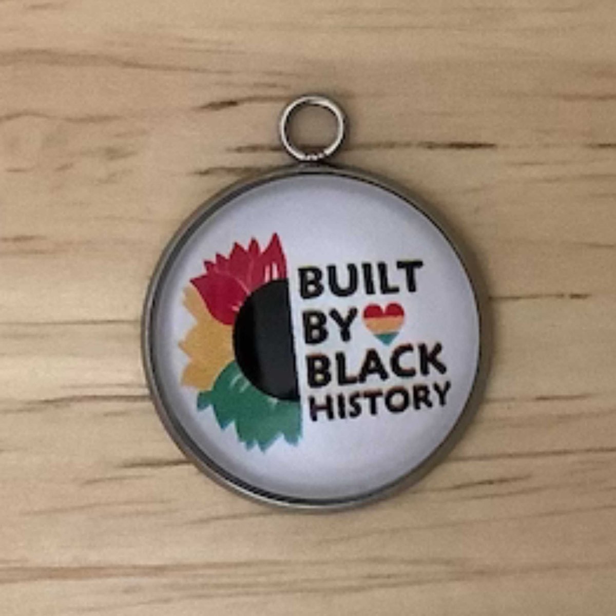 half of a sunflower colored red, yellow, green with the words ' built by black history'