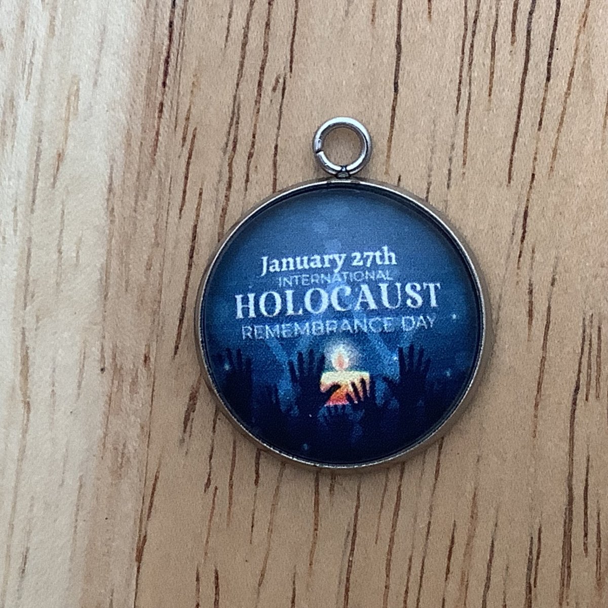 candle, with hands raised. wording 'january 27th International Holocaust Remembrance Day'