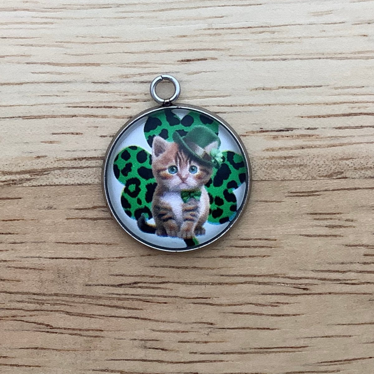 a leopard spotted shamrock with a kitten wearing a green tie and top hat