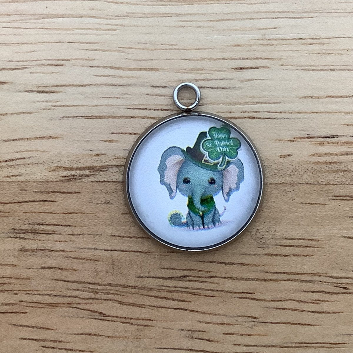 a baby elephant wearing a green hat and vest, with a shamrock that says 'Happy St Patricks, day'