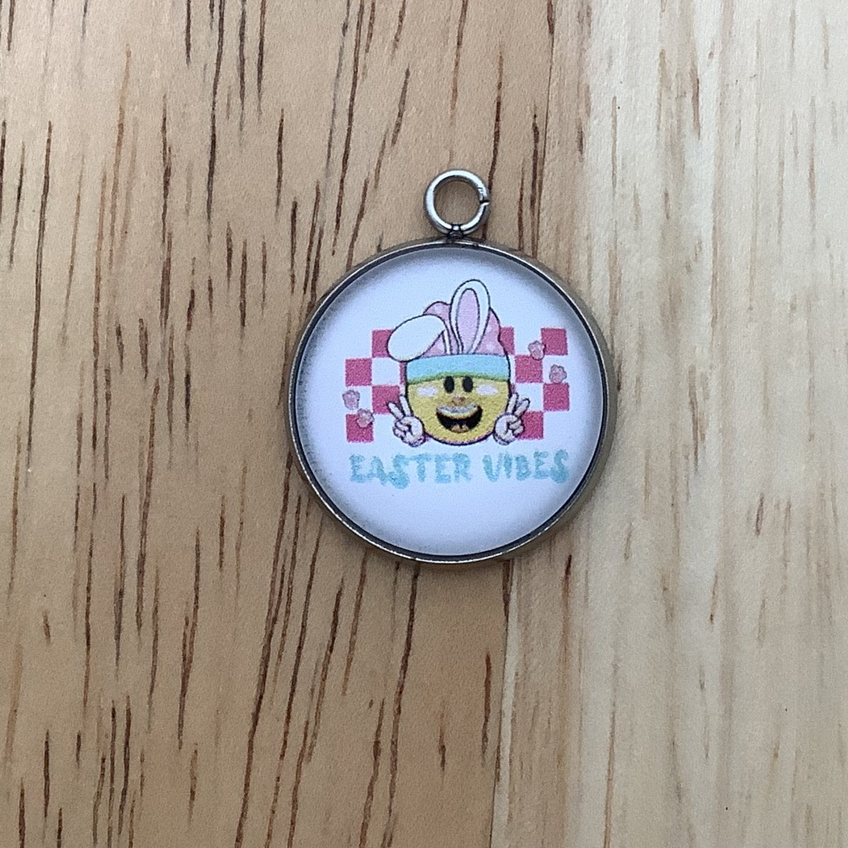 a smiley face type bunny with a chekerboard background and Easter Vibes written below
