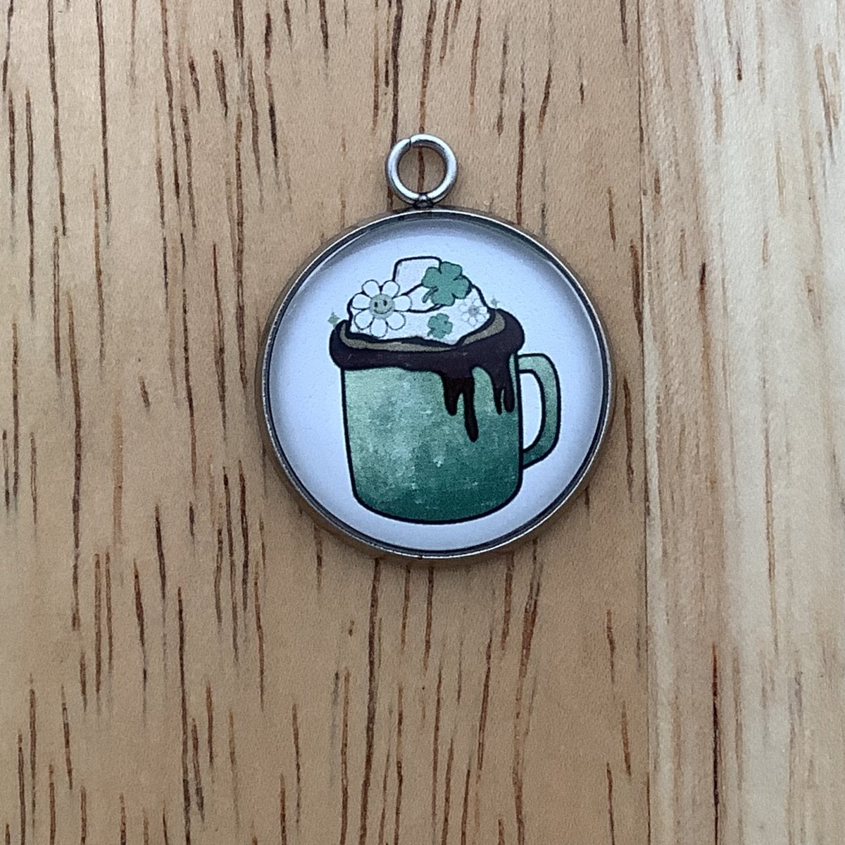a green mug with chocolate dripping over the top, whipped cream on top. a daisy and shamrocks sprinkled on top