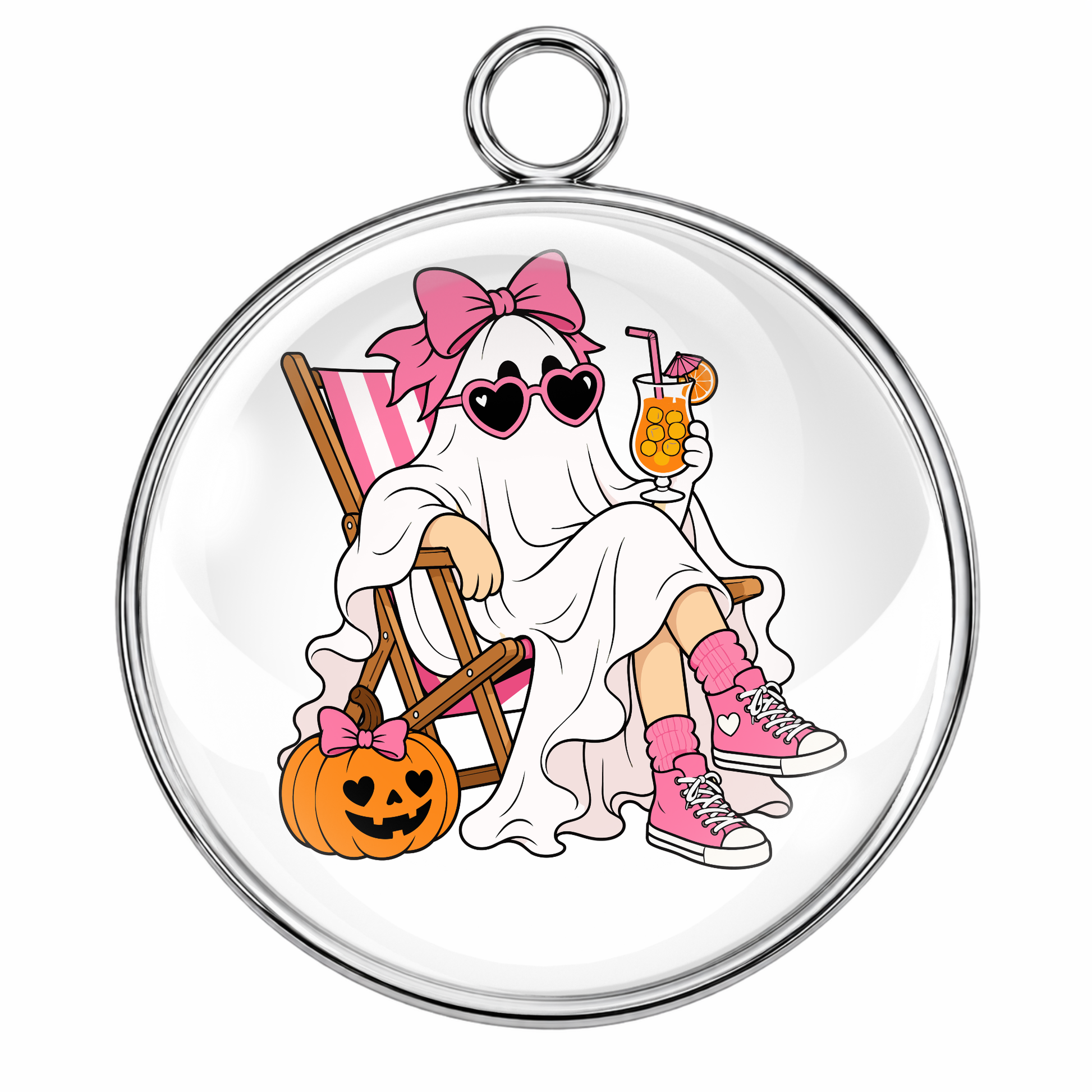 A round glass cabochon charm with a silver metal border and hanging loop, featuring a cartoon illustration of a ghost in a pink bow sitting in a striped chair next to a jack-o'-lantern.