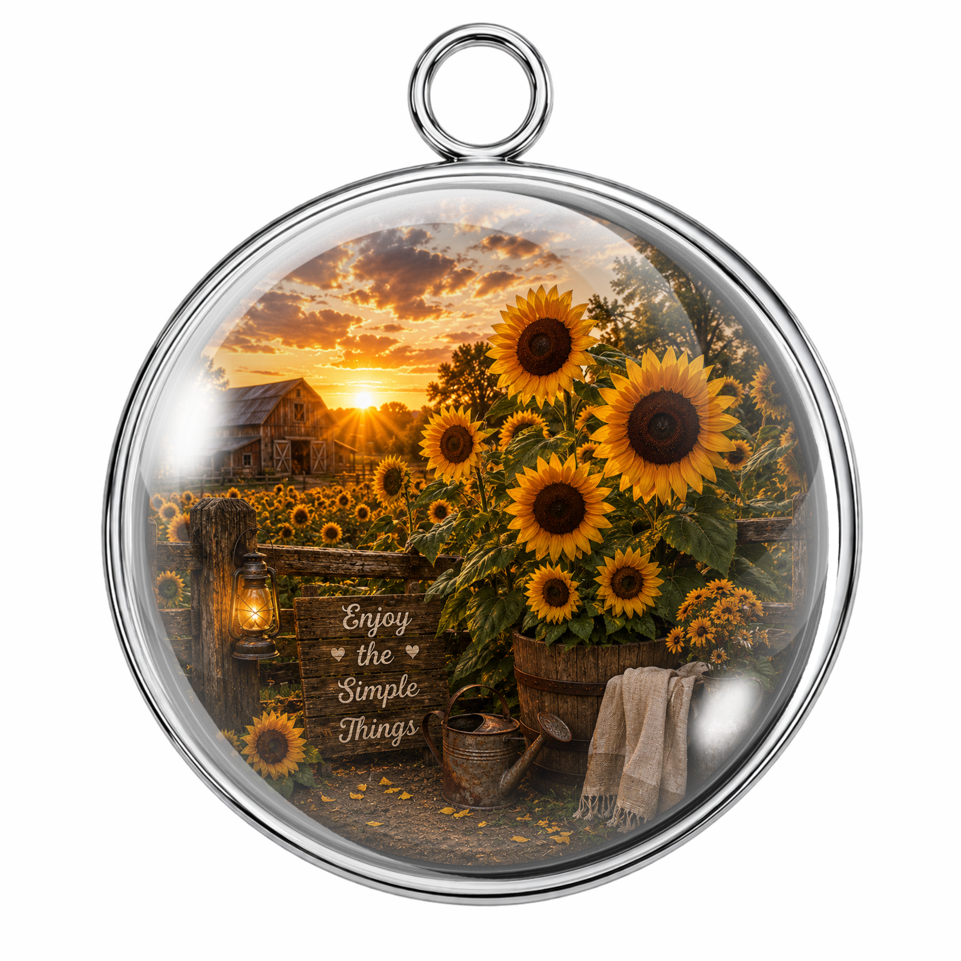 Round silver-toned pendant with a clear glass dome, featuring a sunflower field at sunset, rustic barn, lantern, watering can, and the phrase 'Enjoy the Simple Things' on a white background.
