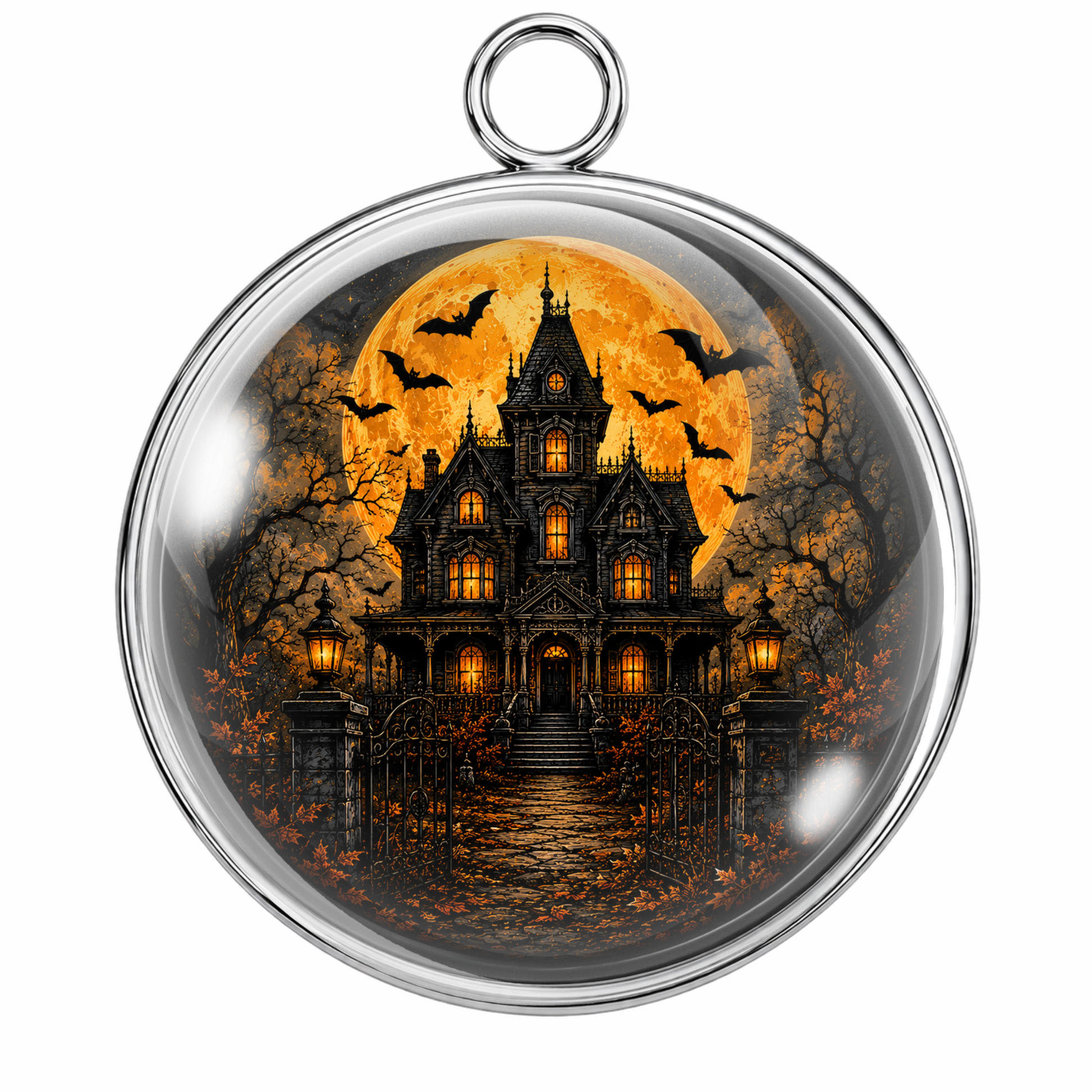 A round glass cabochon pendant with a silver metal rim and hanging loop, featuring a printed Halloween scene of a haunted gothic house under a large orange full moon with bats.