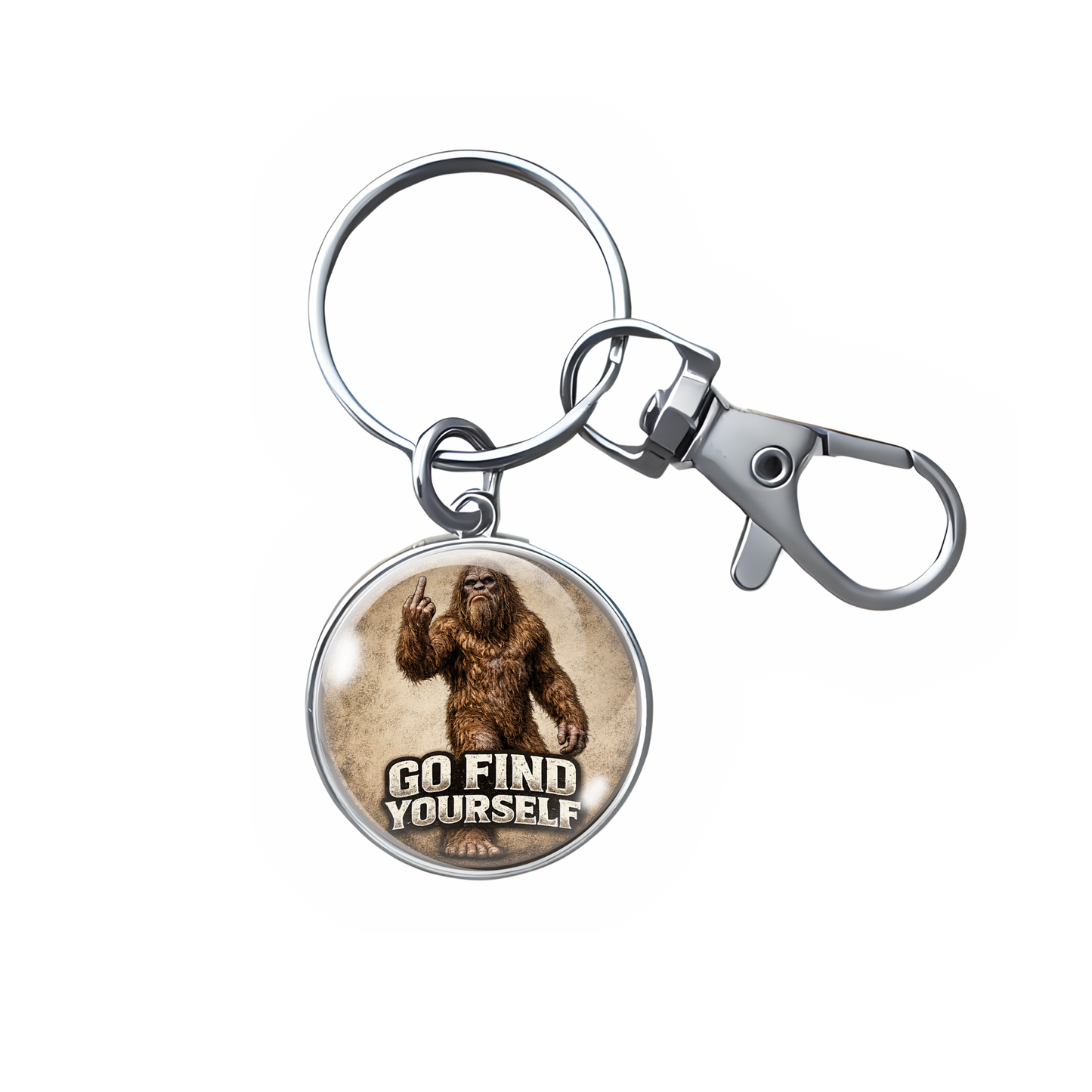 A silver metal keychain featuring a round charm with an illustration of Bigfoot making a peace sign and the text 'GO FIND YOURSELF' on a light beige background.
