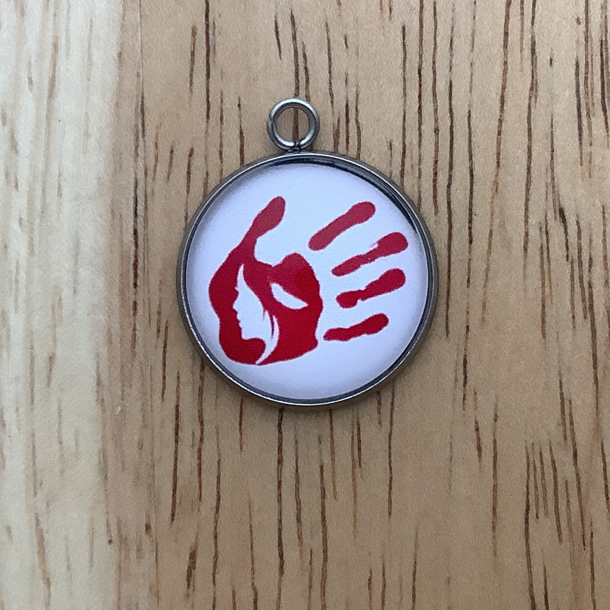 a red handprint with a white silhouette of a native women in the palm