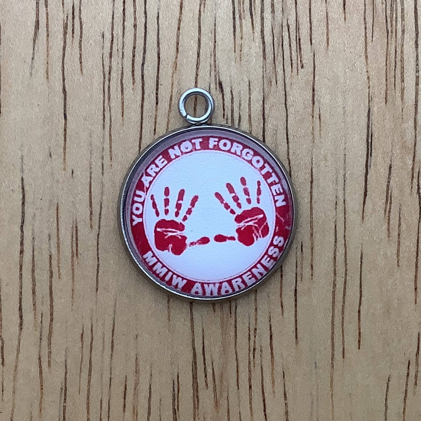 two red handprints with the words "you are not forgotten, MMIW awareness" written around it