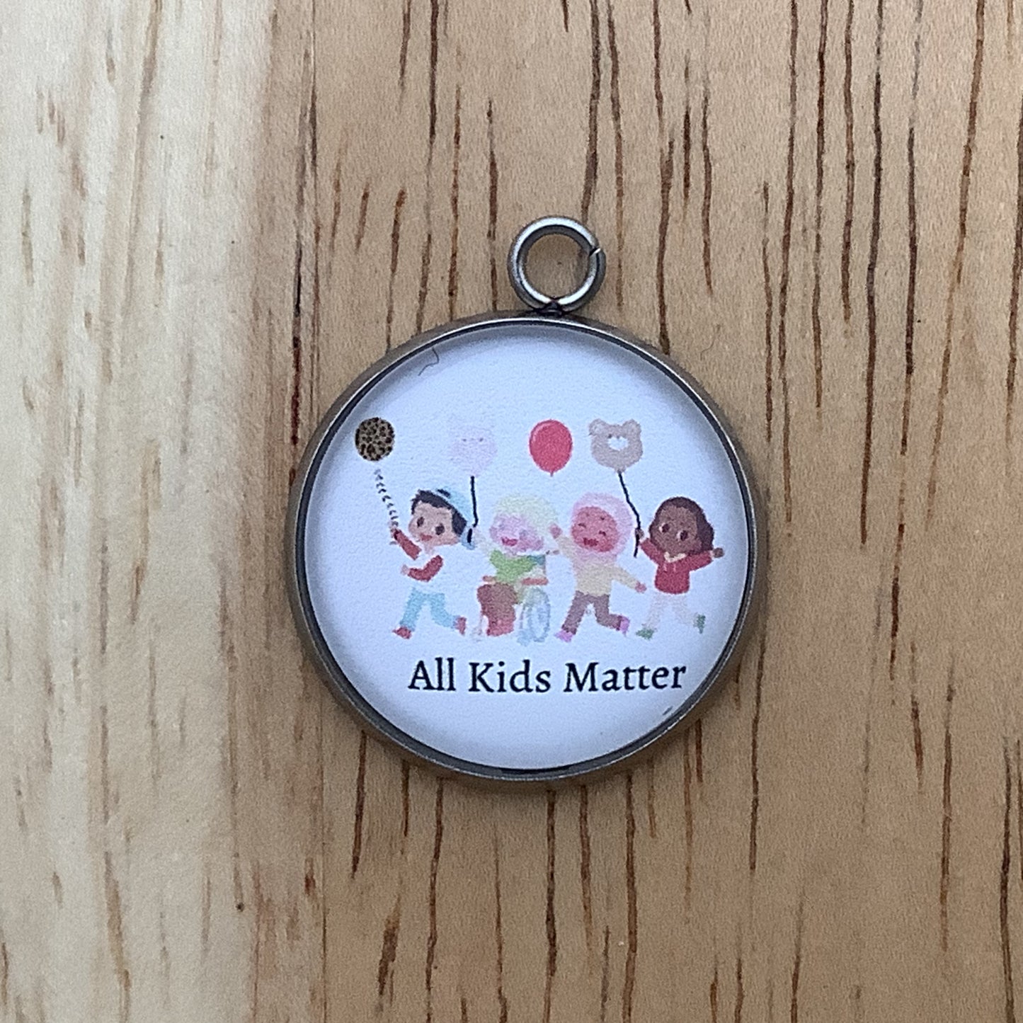 four ethnically diverse kids with balloons and "all kids matter" written underneeth.