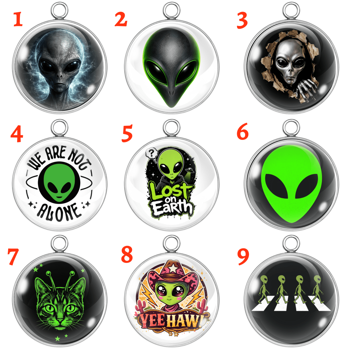 Nine alien-themed pendants with various designs on a white background