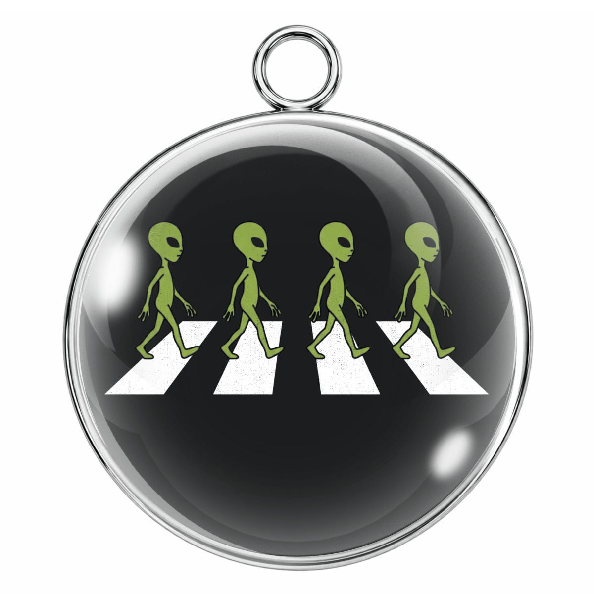 Circular pendant with green aliens crossing a zebra crossing on a black background