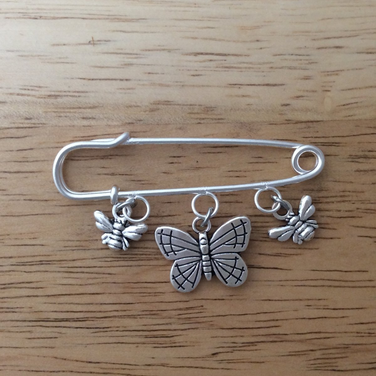 Stainless steel lapel pin with 2 honey bee dangle charms and 1 butterfly dangle charm