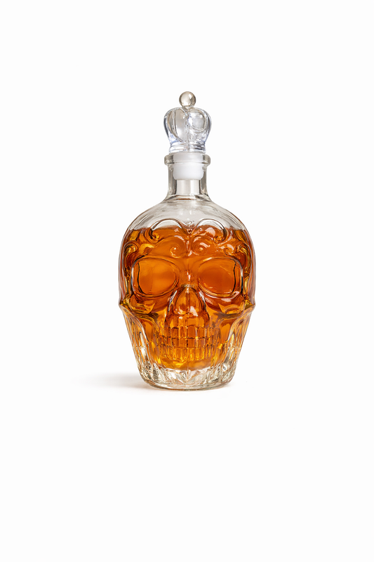 Skull-shaped decanter with amber liquid on a white background