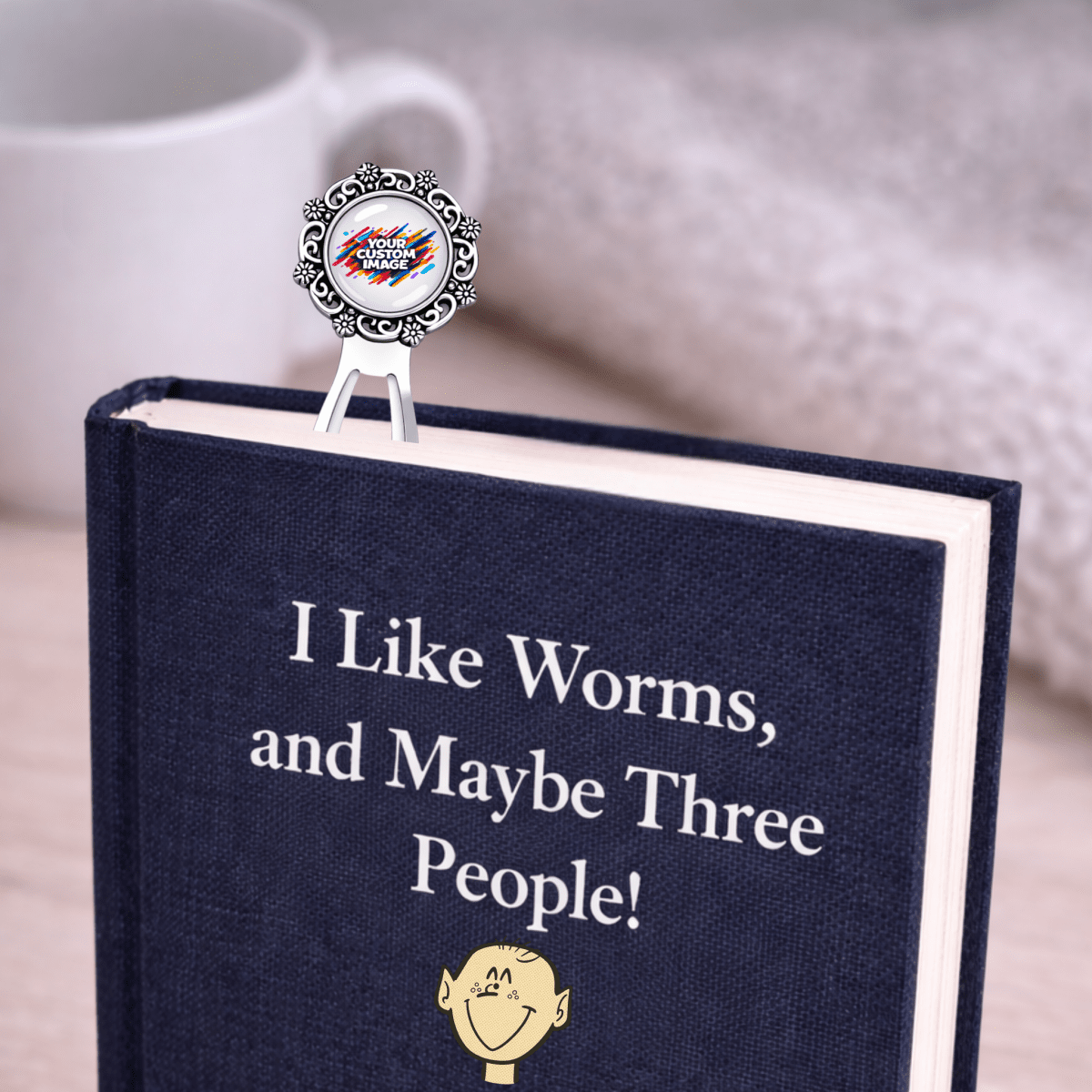 Book with a bookmark titled 'I Like Worms, and Maybe Three People!' on a wooden surface.