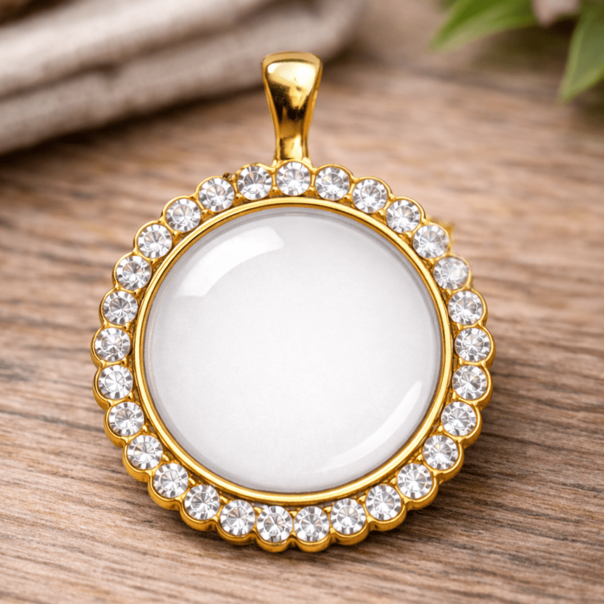 Gold pendant with a white central stone on a wooden surface