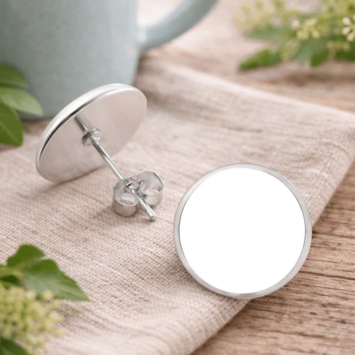 Silver round earrings on a wooden surface with a blurred background
