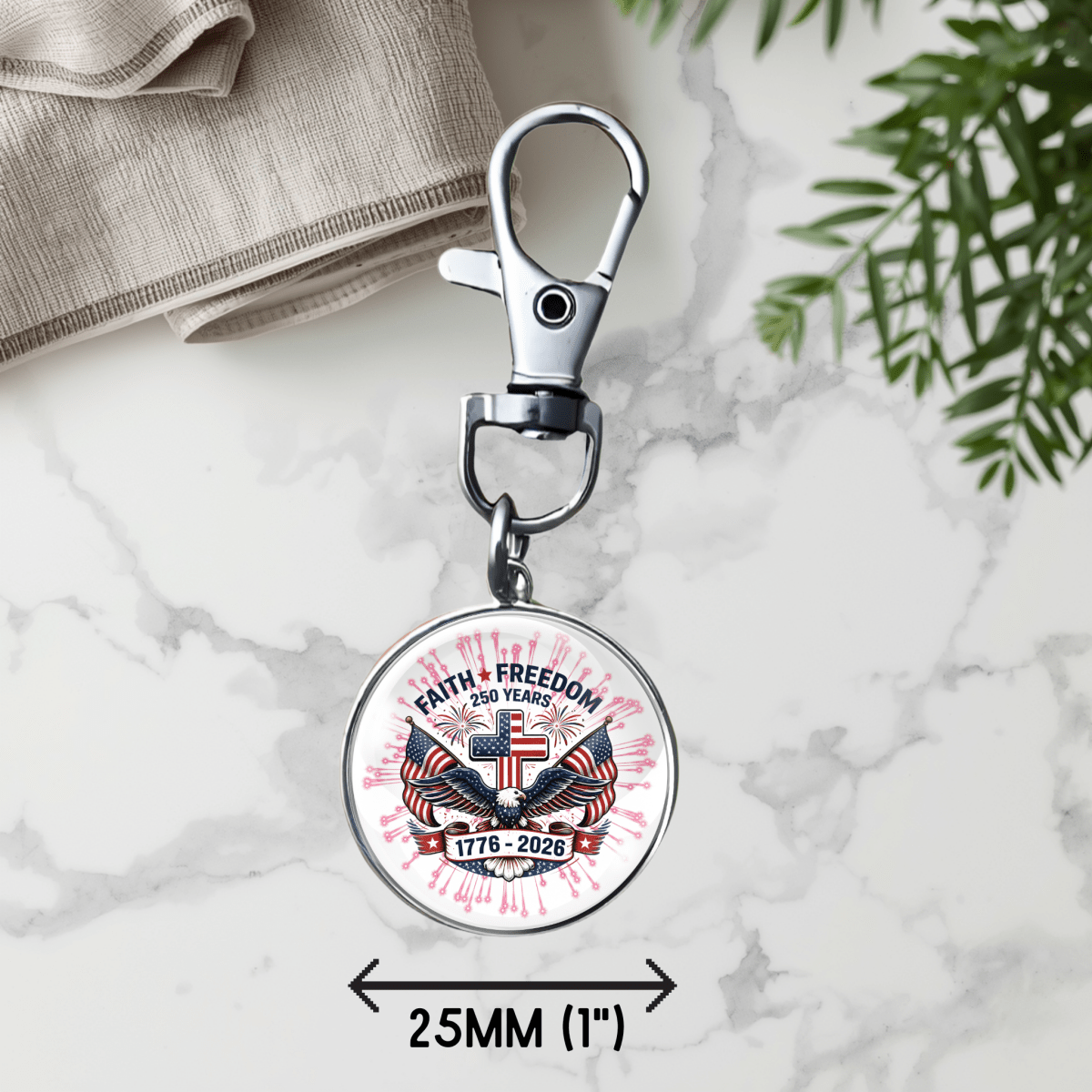 Keychain with 'Faith Freedom' design on a marble surface with plants.