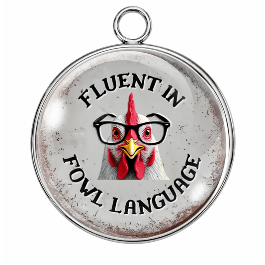 Round pendant with a rooster illustration and text 'Fluent in Fowl Language' on a white background