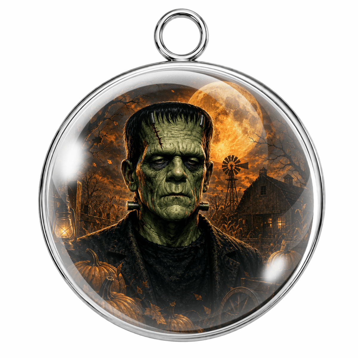 A round silver-toned pendant with a hanging loop at the top, featuring a printed Halloween-themed illustration of Frankenstein's monster under a full moon, set against a plain white background.