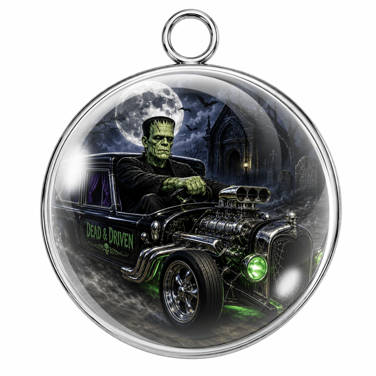 A round silver-toned pendant or ornament featuring a printed horror illustration of Frankenstein's monster sitting in a black hot rod car under a full moon, with a hanging loop at the top.
