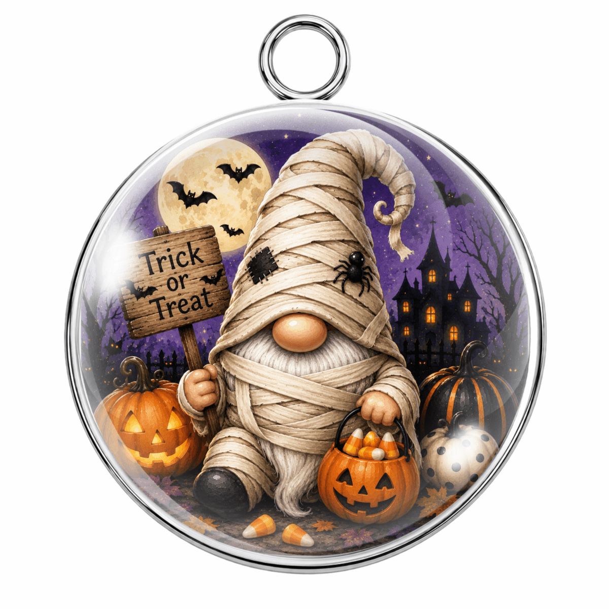 Round glass pendant ornament featuring a mummy gnome surrounded by jack-o'-lanterns, candy corn, bats, a haunted house, and a full moon, with a silver metal loop at the top.