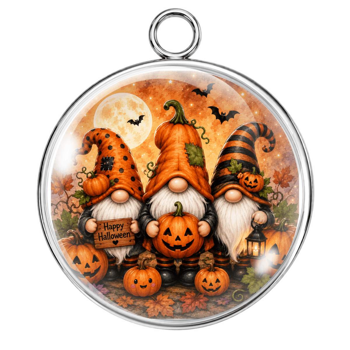 A round silver-toned pendant or ornament featuring a festive Halloween illustration with three orange-grown gnomes, jack-o'-lanterns, bats, a full moon, and autumn leaves under a warm orange sky.