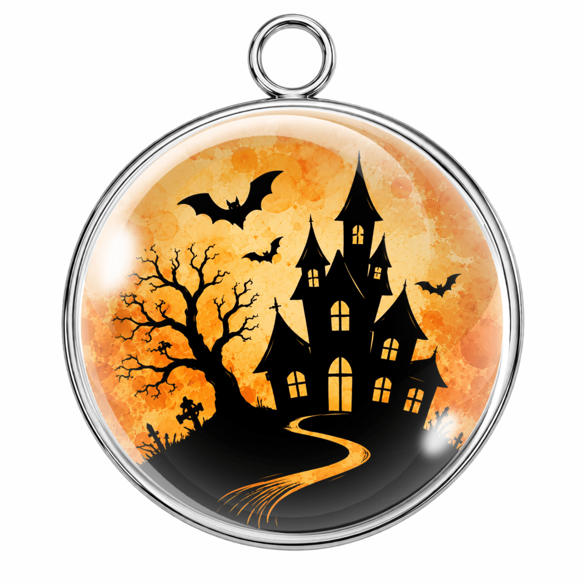 A round pendant with a silver-toned metal bezel and hanging loop, featuring a Halloween night scene with a black haunted house, bare tree, bats, and a glowing orange sky.