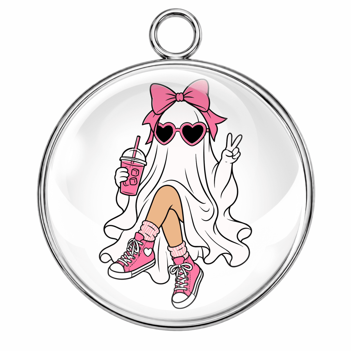 A round silver-toned pendant or charm with a glossy clear dome, featuring a cartoon ghost girl illustration in pink and white with heart-shaped sunglasses, a pink bow, tan leggings, and pink sneakers.