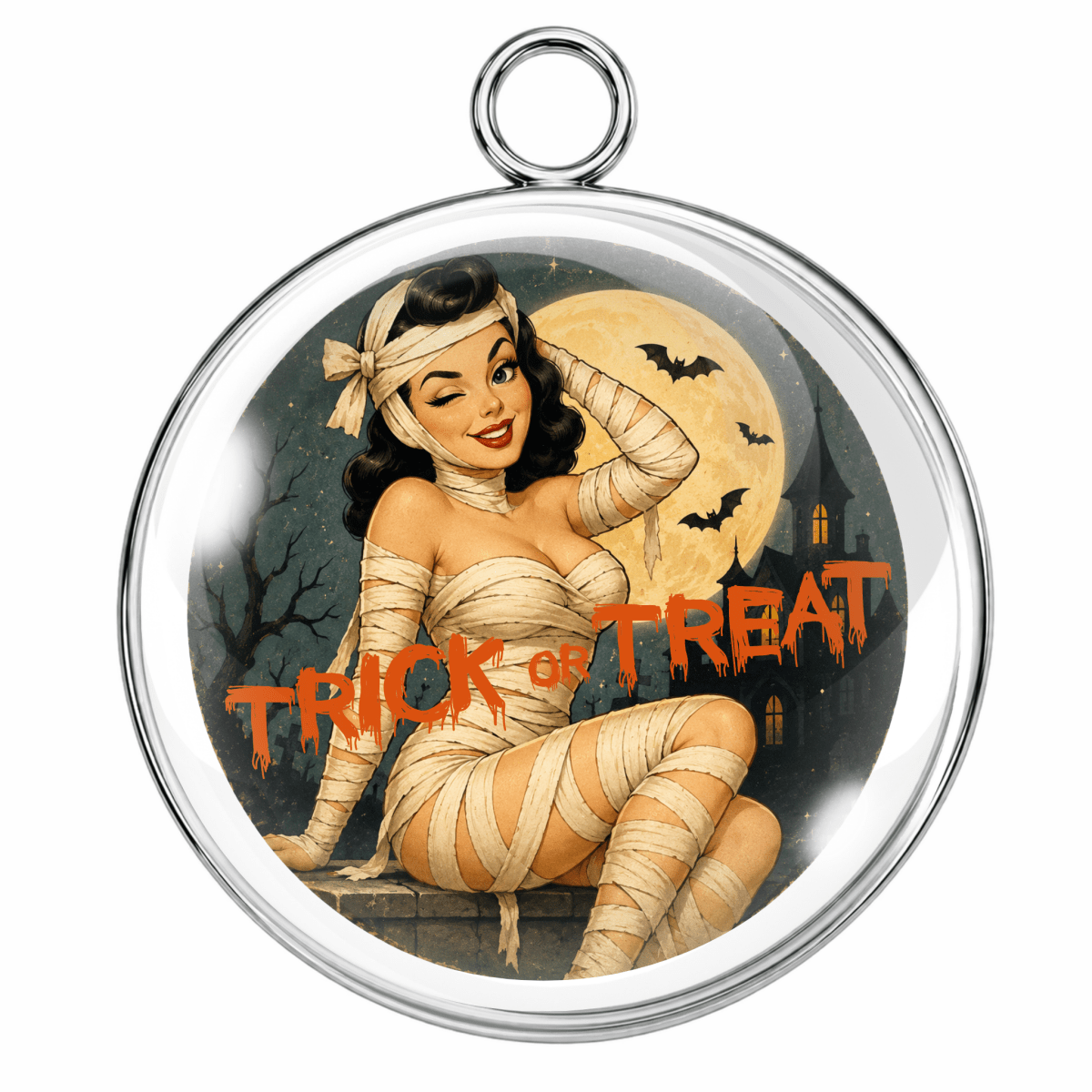 A round silver-toned pendant with a hanging loop at the top, featuring a vintage-style pin-up illustration of a woman wrapped in bandages sitting in front of a full moon with bats and the text 'TRICK OR TREAT'.