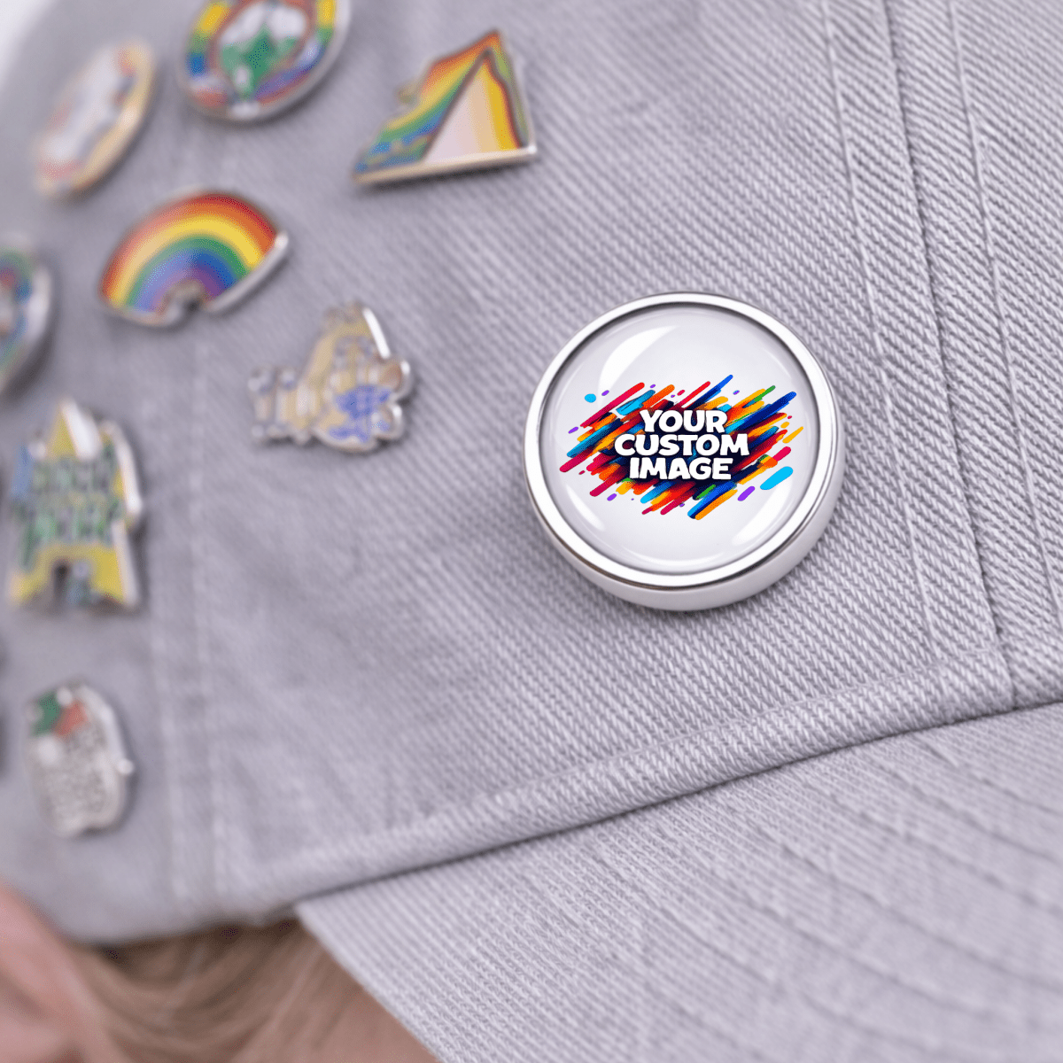 Customizable pin on a gray cap with colorful design and text 'Your Custom Image'.