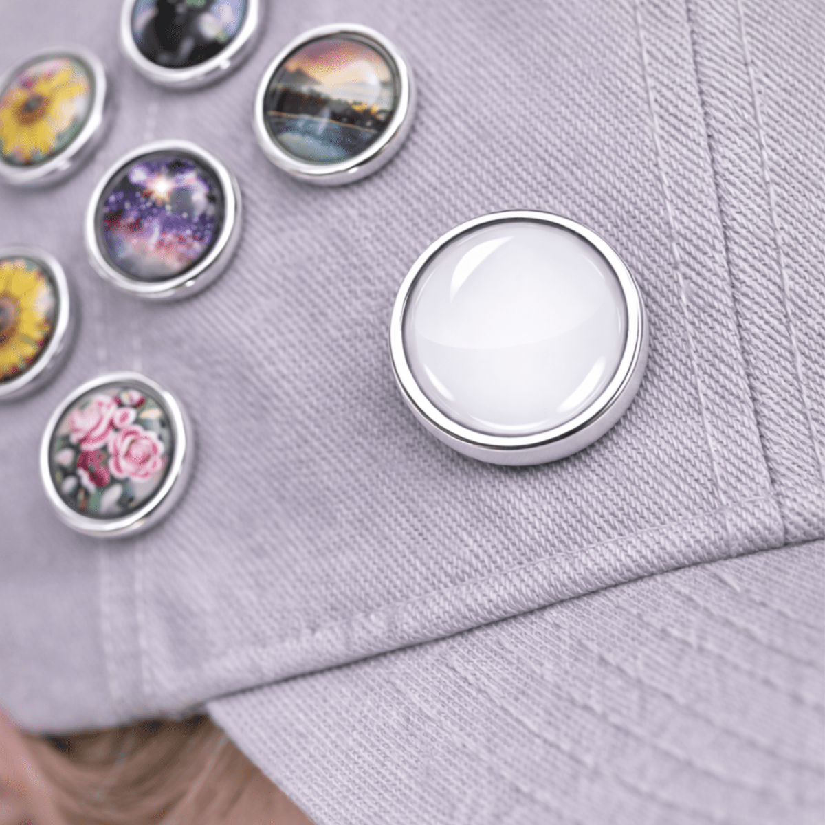 Set of colorful round decorative buttons on a light purple fabric background