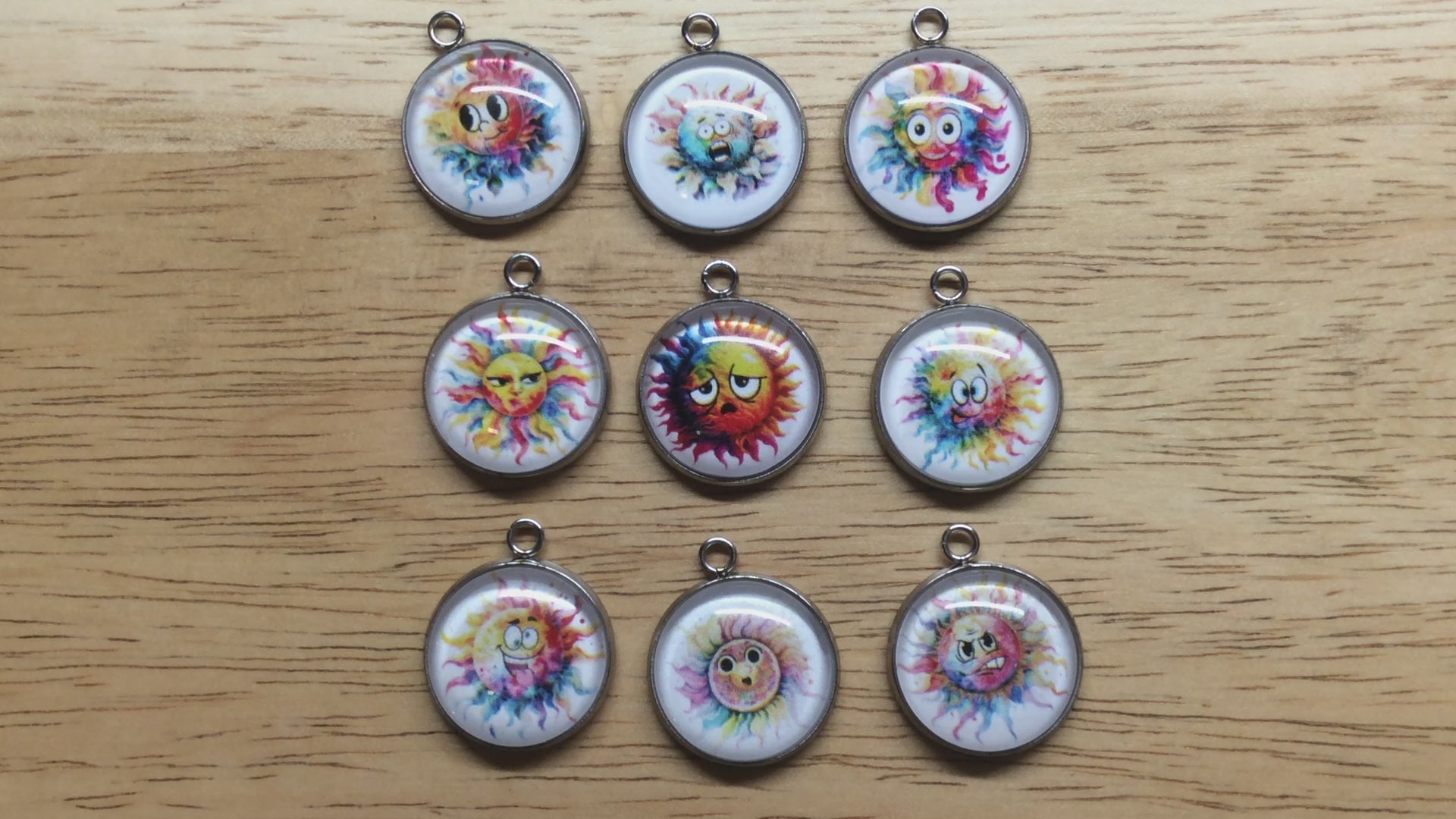 video of 9 Glass cabochon charms with a funny faced, rainbow colored sun