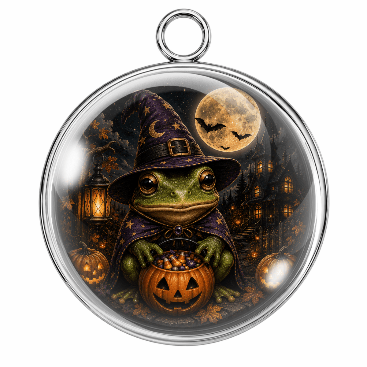 Round silver-toned pendant with a clear domed center featuring a whimsical illustration of a green frog dressed as a witch, holding a jack-o'-lantern, with pumpkins, bats, a full moon, and a haunted house in the background.