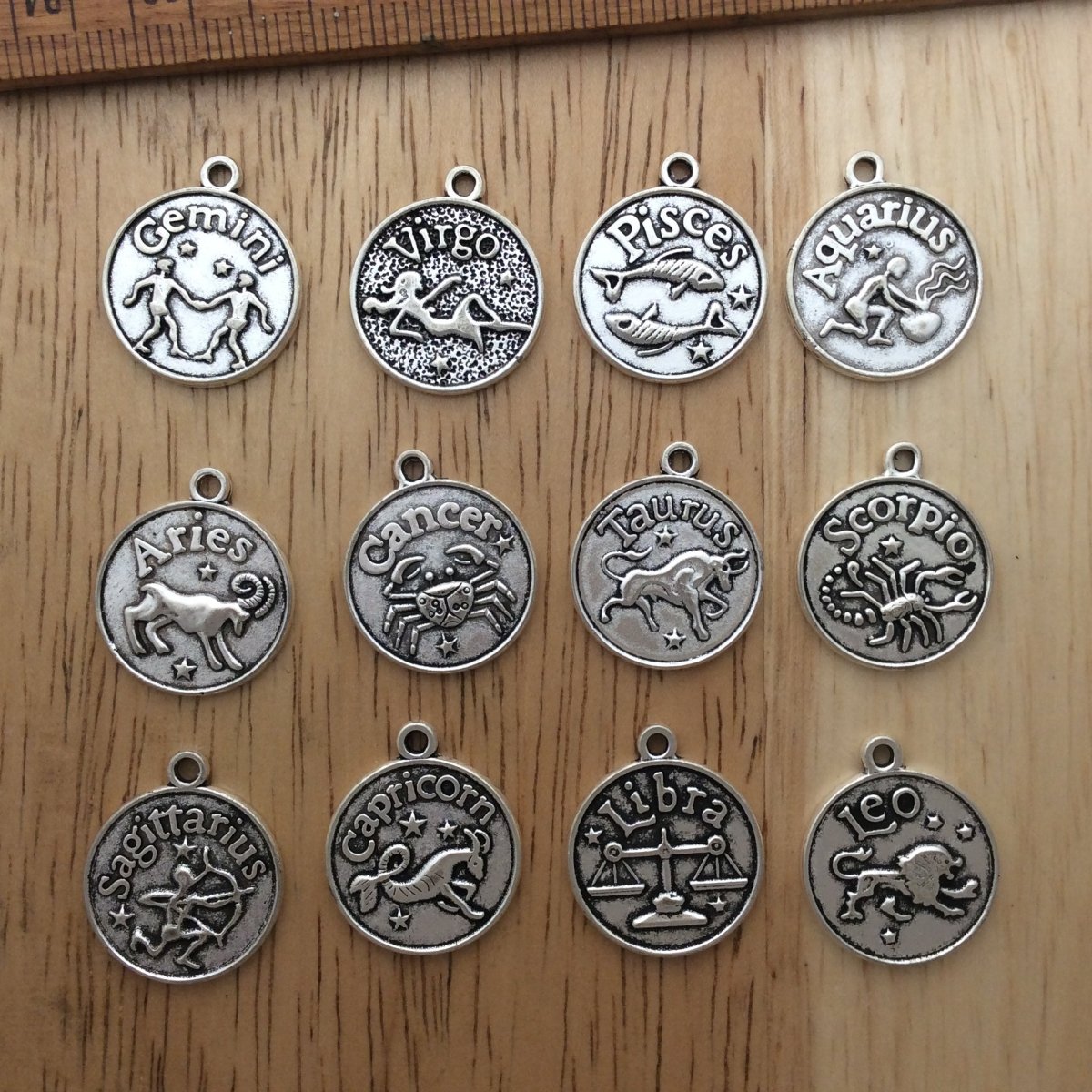 12 zinc alloy zodiac charms.