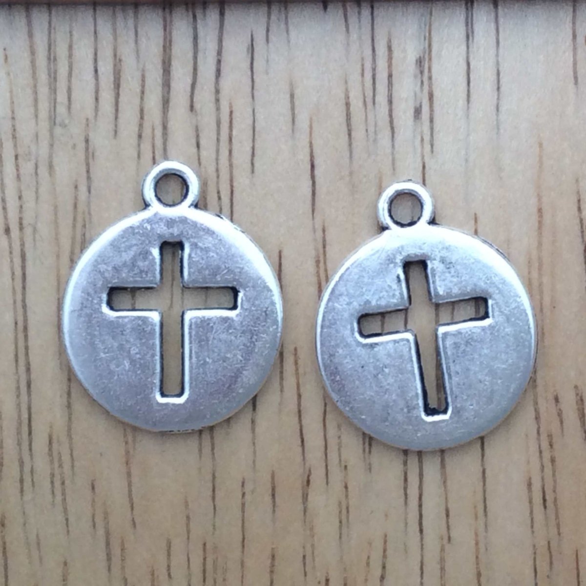 2  round tibetan silver charms with cross cutouts