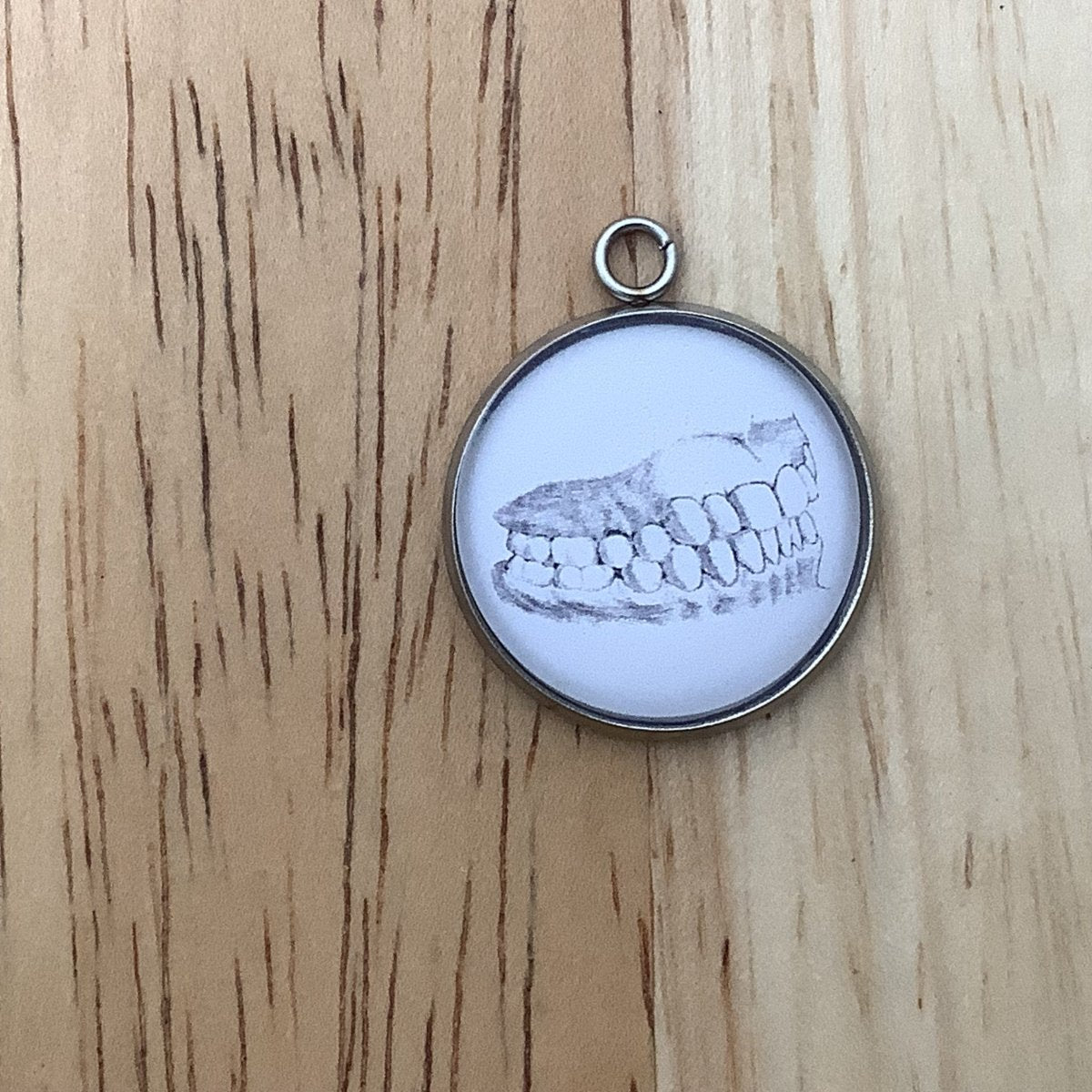 a charm featureing a drawing of human teeth