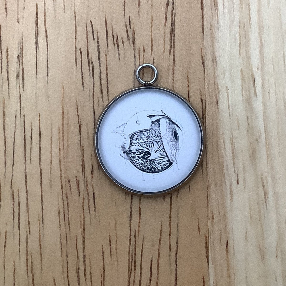 a charm featuring a drawing of the human eye