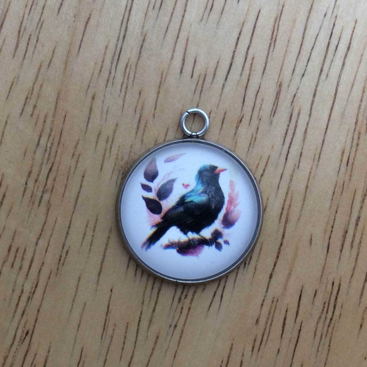 glass cabochon charm with a beautiful black and blue bird