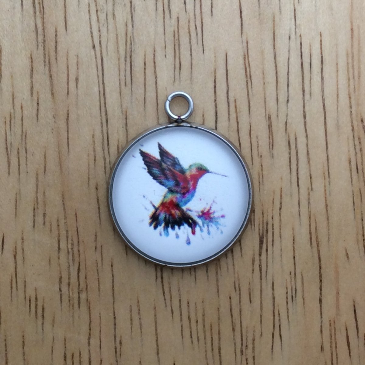 glass cabochon charm with a beautiful multicolored hummingbird