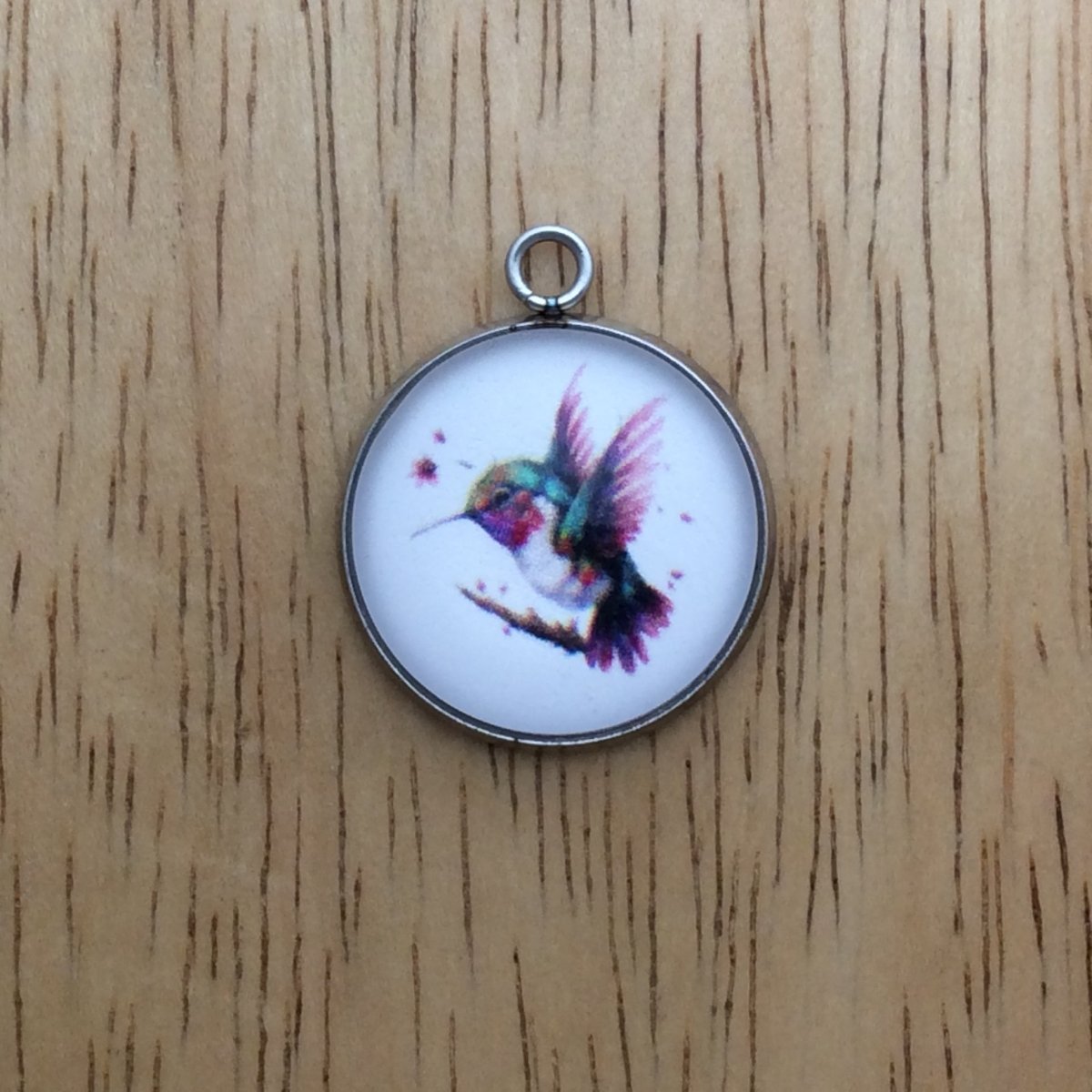 glass cabochon charm with a beautiful multicolored hummingbird