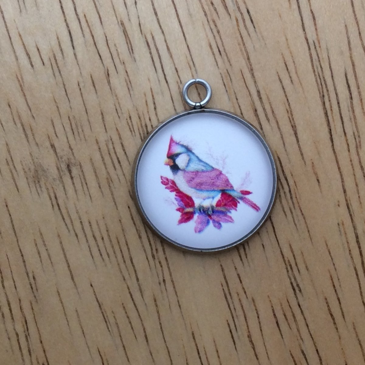 glass cabochon charm with a beautiful multicolored bird