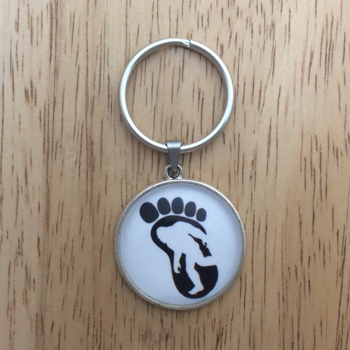 Tibetan silver glass cabochon keyring with a bigfoot walking inside a big foot