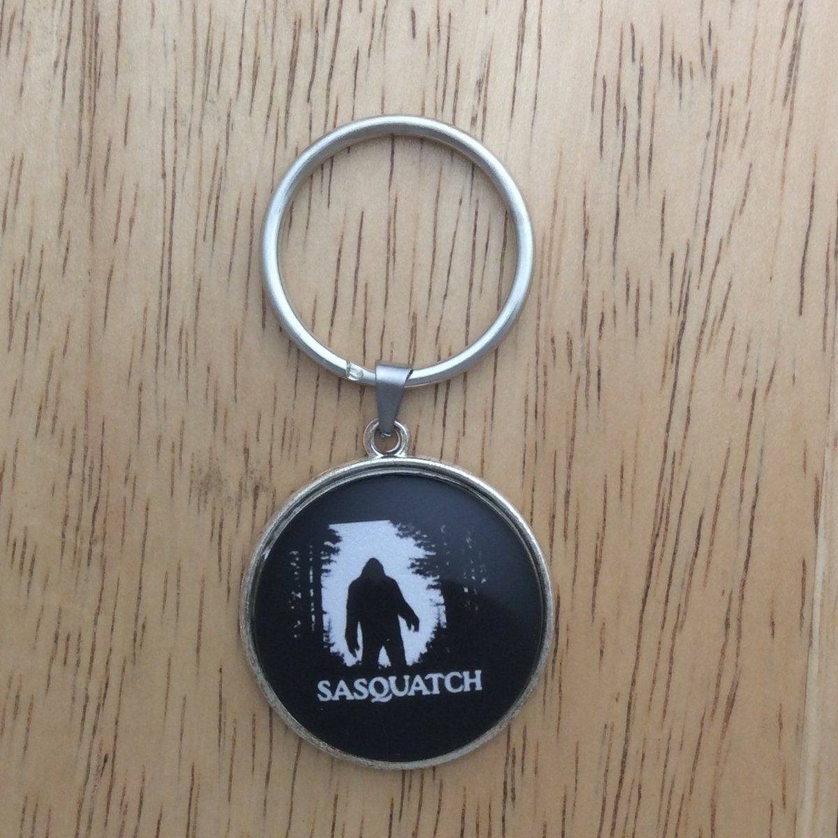 Tibetan silver glass cabochon keyring with a bigfoot walking through the forest and says "Sasquatch"