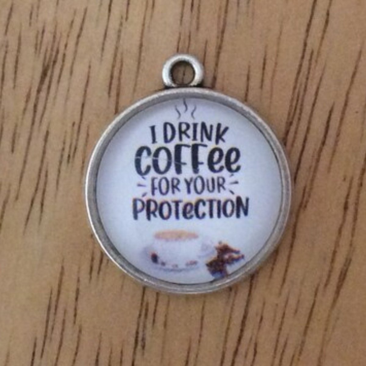 glass cabochon charm that says I drink coffee for your protection with a picture of a coffee cup