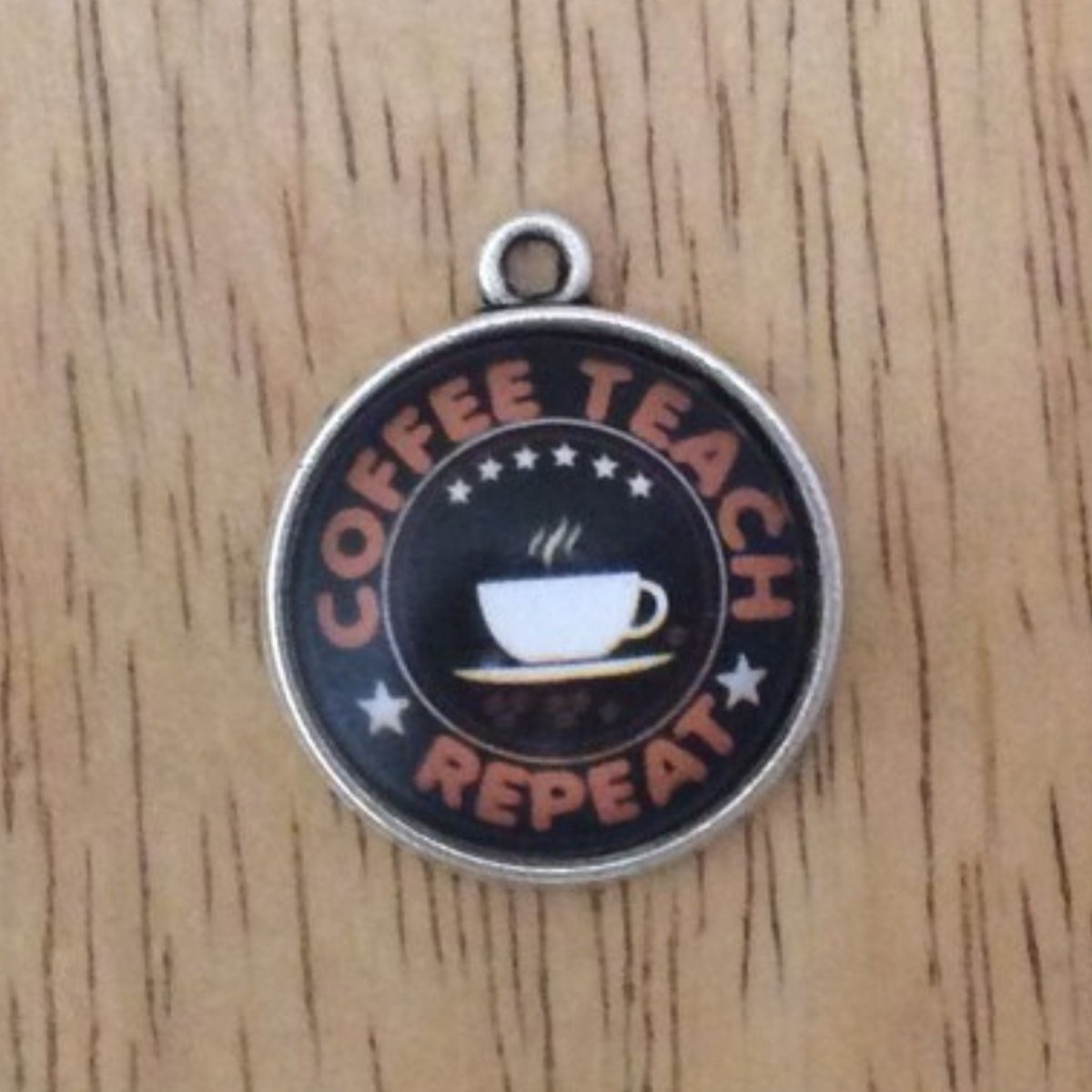 glass cabochon charm with a coffee cup and says coffee teach repeat