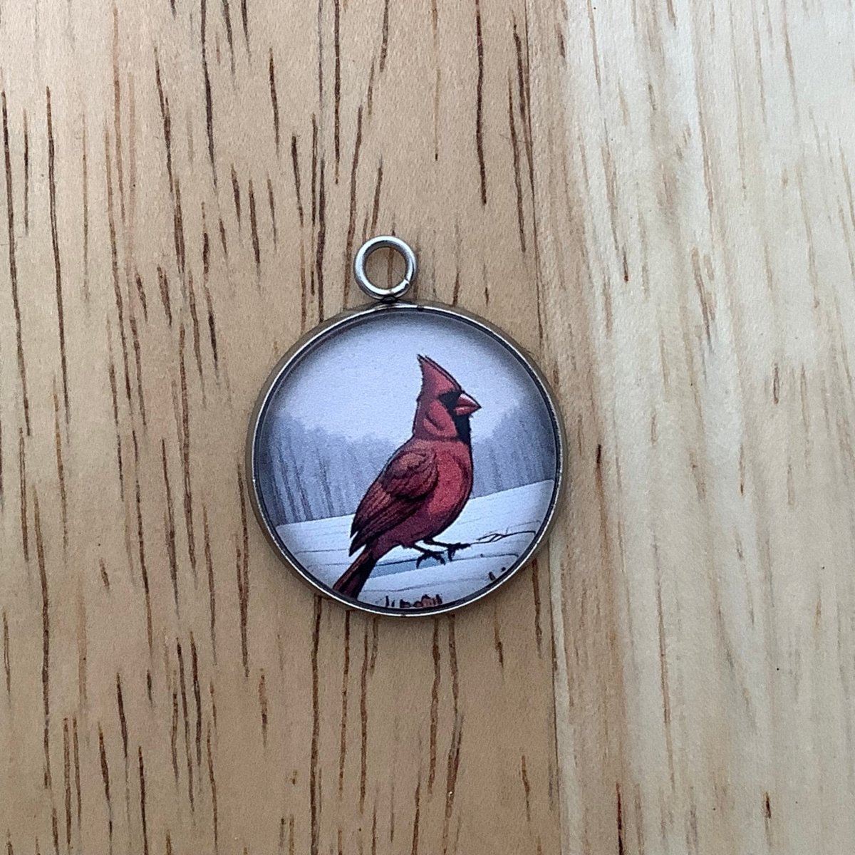 a charm of a cardinal standing on a snow bank