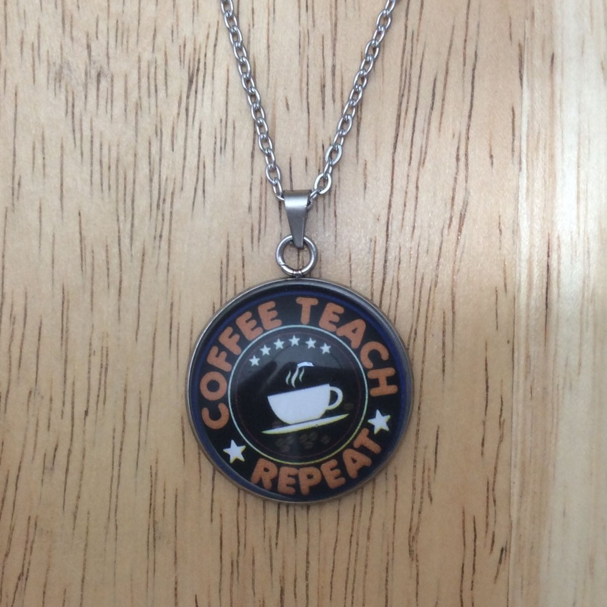 Stainless steel glass cabochon necklace that says "Coffee teach repeat" with a coffee cup