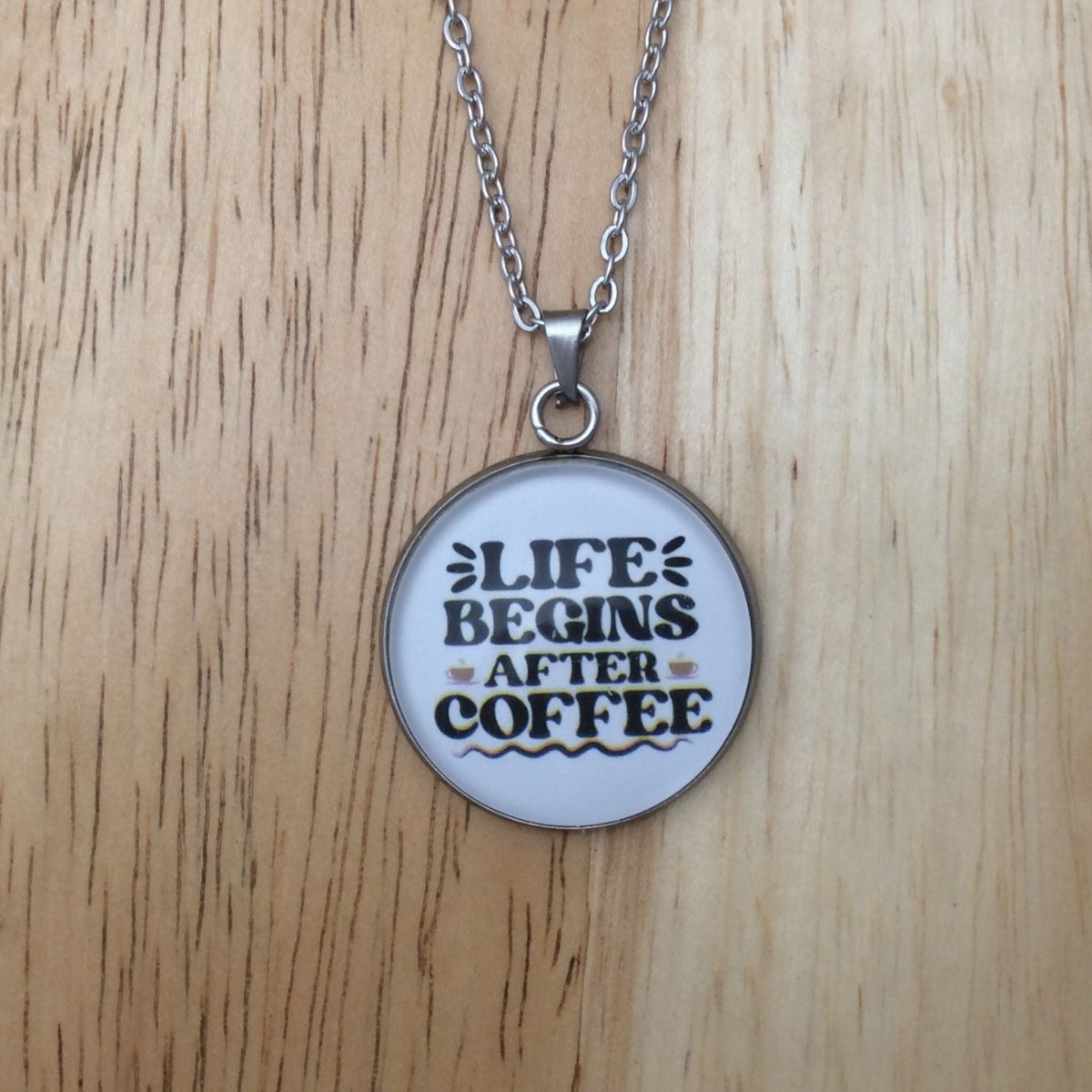 Stainless steel glass cabochon necklace that says Life begins after coffee